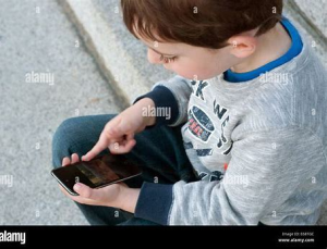 Niño mirando móvil (Source: Alamy - ID:E68TGC)